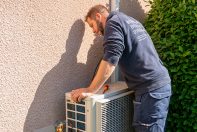 Technicien ClimeHome qui monte un groupe extérieur après avoir procédé son nettoyage