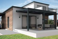 Pergola solaire noir dans une maison individuelle blanche, sous le soleil