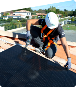 Poseur ClimeHome sur le toit d'une maison individuelle en train de finaliser l'installation d'une centrale photovoltaïque