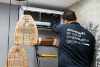 Technicien ClimeHome sur une échelle en train de monter un climatiseur un mur