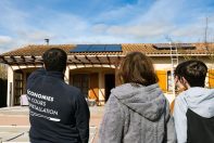 Des propriétaires d'une maison qui observent leur nouvelle installation de panneaux solaires sur leur toit accompagnés du technicien ClimeHome